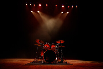 Professional drum set centered on stage with red accents