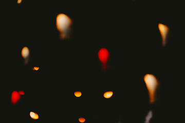 Out of focus abstract warm lights glowing in dark night sky with soft glows