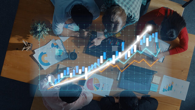 A group of professionals engaging in collaborative work on business strategies. Charts and graphs highlight data visualization for financial growth and planning. Axiom - Powered by Adobe
