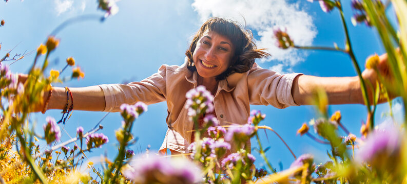 A happy girl. A woman picking wildflowers in a field. A girl in a meadow picking a bouquet of flowers on a summer day.