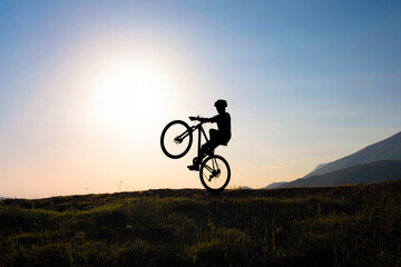 Extreme Cycling Action with Biker Silhouette Against the Sky