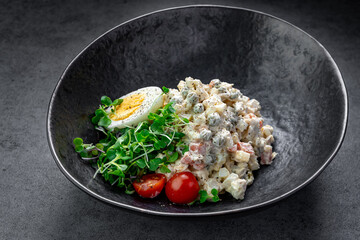 Salad with vegetables and boiled egg in dark bowl. Healthy salad with diced vegetables, egg, and...