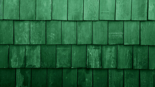 abstract green rustic wood shingles texture background. green weathered cedar shake wall siding. Grunge timber roof surface pattern with rough vertical grain details for architectural design.
