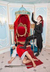 Beautiful redhaired woman warrior with sword standing under the fallen tyrant