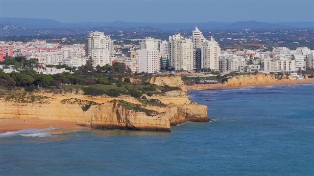 Algarve Luxury Real Estate: Panoramic 4K Aerial View of Premium Villas and Resorts in Arma&ccedil;&atilde;o de P&ecirc;ra Overlooking the Turquoise Coastline of Praia de Albandeira, Portugal