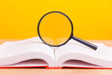 Magnifying glass on the book - Study time conceptual image of education and knowledge