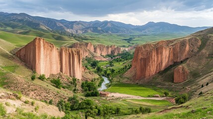 Majestic Red Rock Cliffs Guard Verdant Valley with Winding River and Distant Mountains