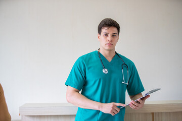 Portrait of adult man doctor stand with clipboard on the terrace