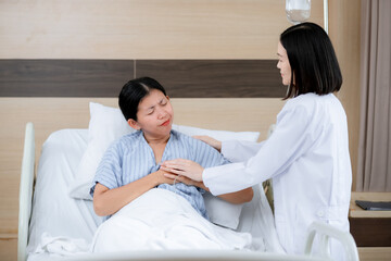 female patient lying in a hospital bed, appearing to be in pain as she clutches her chest with a pained expression. A doctor stands beside her, gently holding her hand and offering support while asses