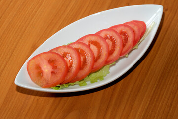 Fresh tomato slices arranged beautifully on a white platter