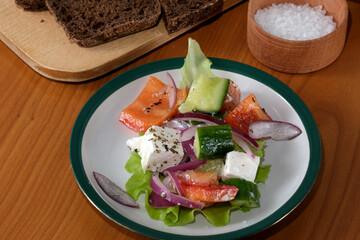 Fresh salad served on a vibrant plate with bread and salt