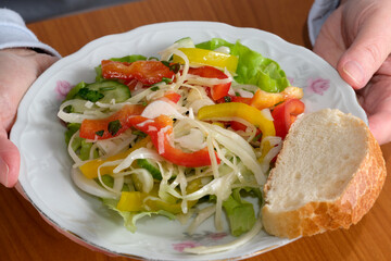 Colorful salad served with fresh bread on wooden table