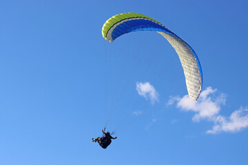 Paraglider flying in a blue sky	