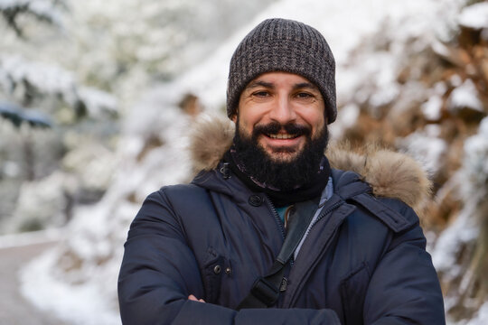Smiling bearded man in the snow looking at camera