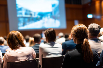 People students attending a lecture at an auditorium, view from back