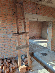 The interior of an unfinished cottage with brick walls