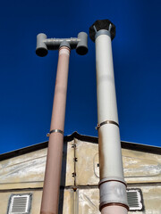 Two plastic exhaust or ventilation pipes in garage for automobile