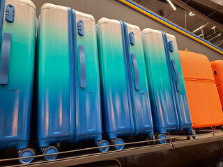 Blue large suitcases are on the counter in the store
