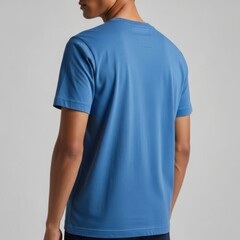 Man seen from the back wearing a comfortable blue t-shirt with a subtle label detail on the collar area.
