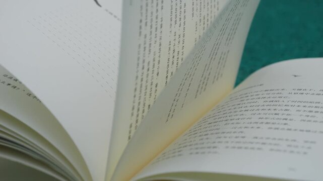 Open Book with Asian Text on Teal Background