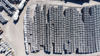 Imagem a&eacute;rea de blocos de concreto empilhados em &aacute;rea industrial mostra a fabrica&ccedil;&atilde;o de materiais estruturais usados na constru&ccedil;&atilde;o civil e em projetos de infraestrutura.