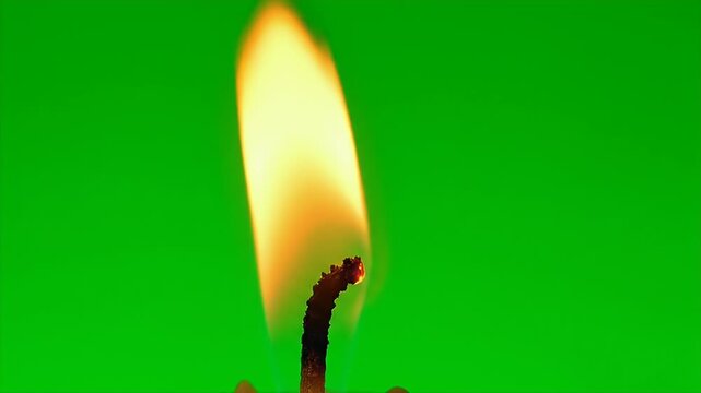 Candle Flame on Green Screen - A close-up shot showcases a brightly lit candle flame, set against a vibrant green screen background.