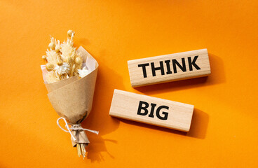 Think big symbol. Wooden blocks with words Think big. Beautiful orange background. Business and Think big concept. Copy space.