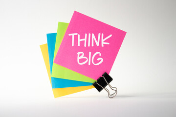 Think big symbol. Pink sticky note with words Think Big. Beautiful white background. Business and Think big concept. Copy space.