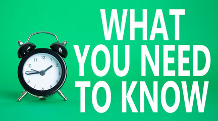 What You need to Know symbol. Wooden blocks with words What You need to Know. Beautiful green background with alarm clock. Business and What You need to Know. Copy space.