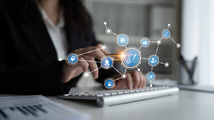 A business professional interacts with floating e-commerce icons using a computer in a modern...