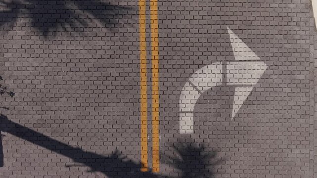 Overhead of stone paver road with white painted turn arrow