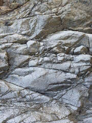 Rock formations along the coastline show various textures and colors