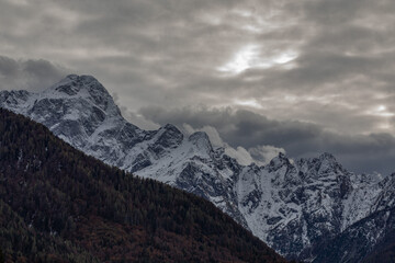 catena montuosa innevata e lontana nelle Alpi Italiane nell'area nord-est della regione Friuli Venezia Giulia, al tramonto, in inverno, con cielo coperto