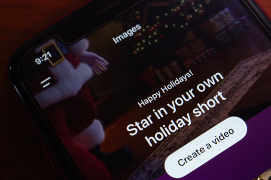 Quito, ECUADOR - Dec 23 2025 : Close-up of smartphone screen showing ChatGPT Images interface with holiday video prompt, festive bokeh lights softly blurred in background.
