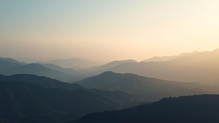 A serene mountain landscape at sunrise with a hazy sky