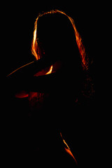 Expressive silhouette portrait of a woman captured with dramatic edge lighting, highlighting confidence, movement, and refined artistic style for modern branding and creative use.