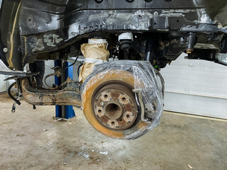 protection during painting, axle covered with protective layers, masking and cover application for axle painting, applying masking and tape to safeguard axle during painting process