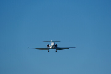 Business Aircraft Final Approach to Airport – Close-Up in Azure Blue Sky. Business Jet Approaching Runway for Landing in Clear Blue Sky