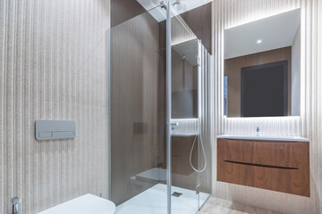 Elegant bathroom design with a modern shower behind a glass partition. Beautiful wall decoration, stylish lighting.