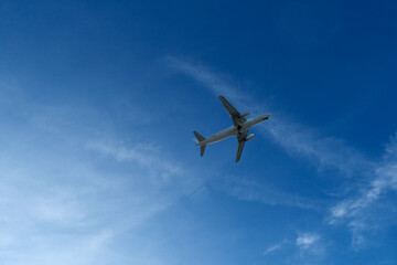 Fototapeta premium Airplane in the cloudy sky. White Plane Climbing Through Clouds Half a Minute Post-Takeoff.