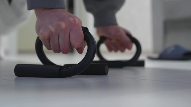 Push-ups.
A muscular man doing push-ups on the parallel bars.
A man in good athletic shape exercises and tones his muscles.