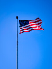 America flag waving high in the blue bright sky, a sign of promise and hope