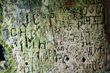 Words and letters carved into an ancient stone wall
