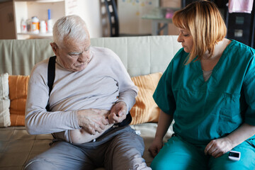 Obraz premium Home Healthcare Nurse Checking Blood Sugar of Elderly Man – Diabetes Care