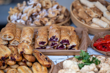 Rustic stall selling diverse baked goods, Bustling market booth with colorful snacks and local treats