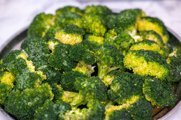 Vibrant green vegetable display, Appetizing arrangement of fresh broccoli florets under kitchen lighting