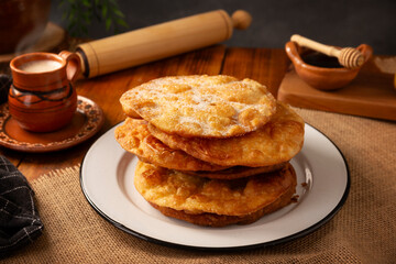 Bu&ntilde;uelos de rodilla. Traditional food at Christmas and winter holidays in Mexico, these are fried dough flour sprinkled with sugar or covered in a syrup made with piloncillo, cinnamon, and guava.