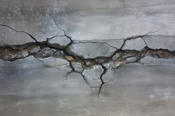 Cracked concrete surface shows signs of damage and wear in a construction area during daylight hours in an urban setting