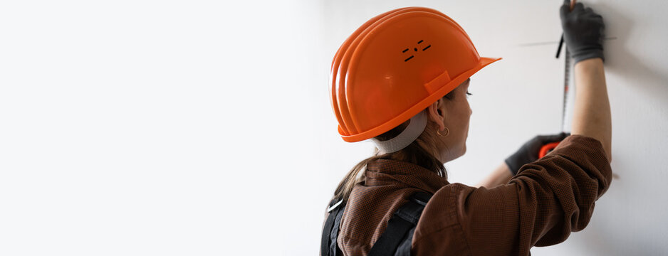 architect in hardhat measuring wall using steel ruller. architecture and home renovation concept