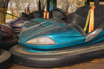 A bumper car covered in dust at an amusement park during the off-season